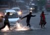 Pedestrians crossing waterlogged road in Jammu on Saturday. —Excelsior/Rakesh
