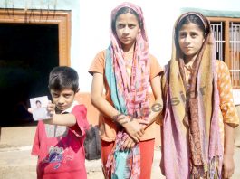 Children of slain truck driver displaying a photograph of their father. -Excelsior/Rakesh