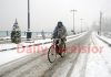 A cyclist moves on a snow clad road in Srinagar on Sunday. — Excelsior / Shakeel