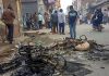 Passersby look at the charred remains of vehicles which were set ablaze by rioters during clashes at Mustafabad area of East Delhi on Wednesday.