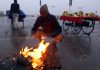 A vegetable vendor warms himself around fire in Jammu on Sunday. — Excelsior/Rakesh
