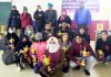 Winning players posing for a group photograph with their trophies at Shopian.