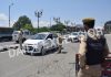 Cops check a car moving on Srinagar road during lockdown on Sunday. — Excelsior/Shakeel