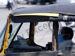 A three-wheeler operator reads a newspaper as he waits for passengers in Jammu on Monday. —Excelsior/Rakesh