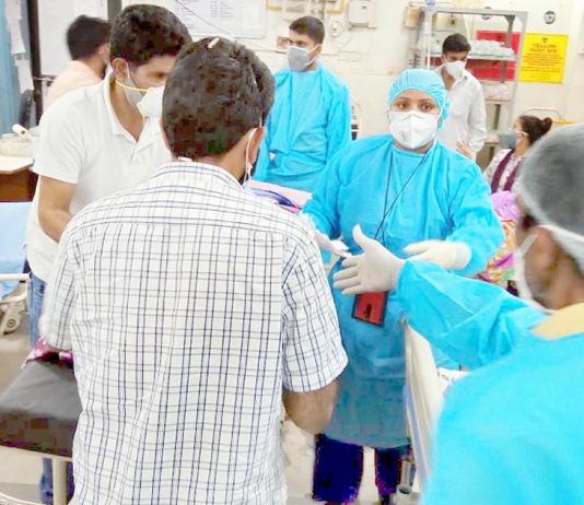 Attired in PPE Kits, SDRF men assisting in Covid wards at Government Medical College Jammu on Tuesday. (UNI)