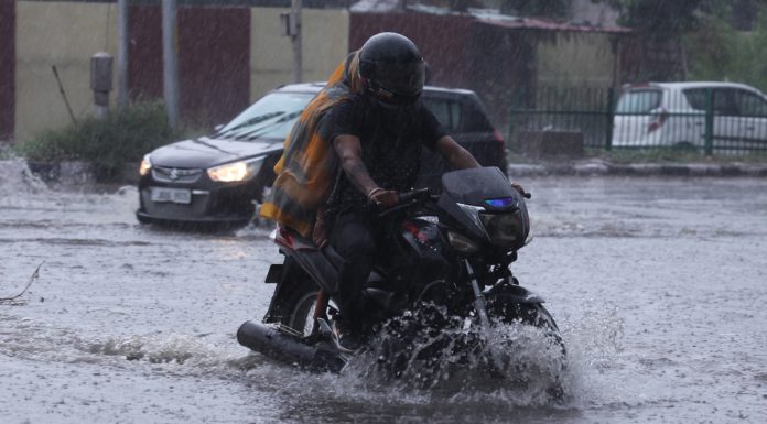 A bike rider moving through a flooded road in Gandhi Nagar area of Jammu on Saturday. — Excelsior/Rakesh