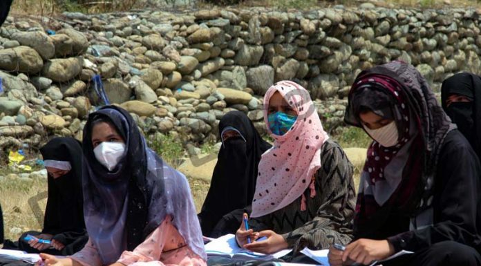 Students wearing protective face masks attend an Open-Air-Class in Tangmarg area of Baramulla district. —Excelsior/Aabid Nabi