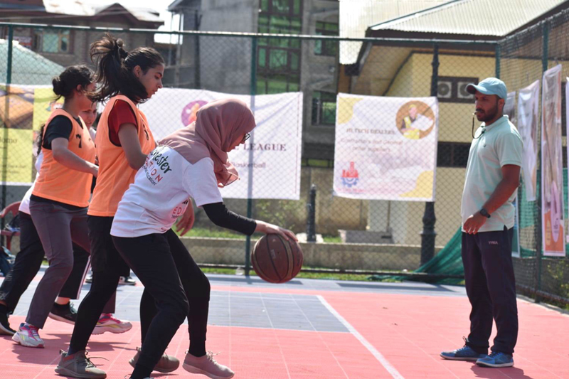Players in action during Basketball match being played at Gindun Sports Center Srinagar on Tuesday.