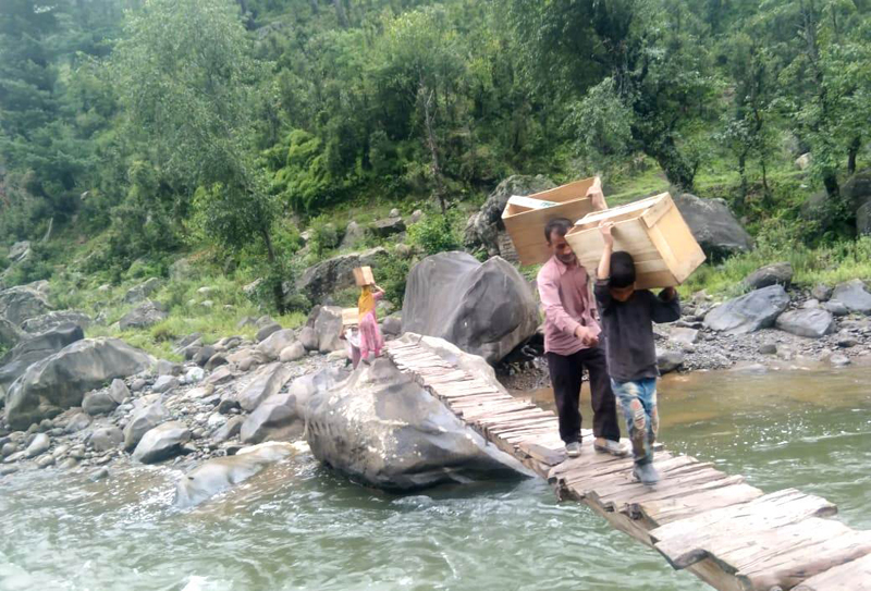 Locals crossing temporary wooden bridge over Tawi River at village Jig & Chaj in Chenani Tehsil. - Excelsior/K Kumar