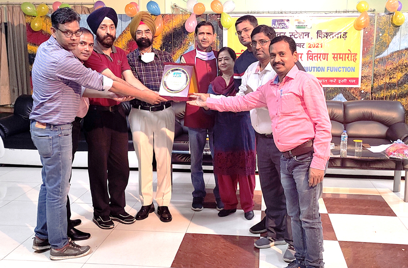 GM (In-Charge) Dulhasti Power Station Nirmal Singh and other staff members posing together while holding a trophy.
