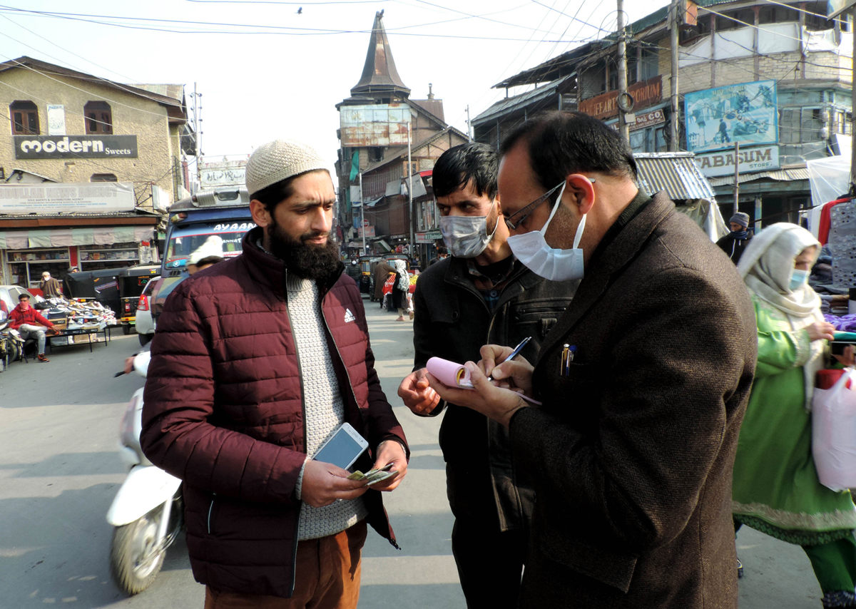 People being fined for not wearing face masks in Srinagar on Saturday.(UNI)