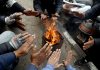 People warming themselves on roadside as mercury plummets across Kashmir. — Excelsior/Shakeel