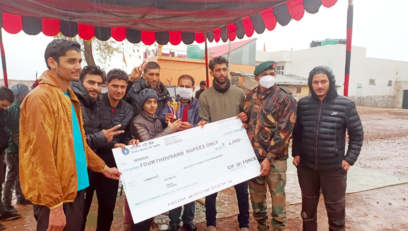 Winning team being awarded with the cash prize by an Army official at Batote.