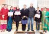Winners displaying meritorious certificates while posing with dignitaries at Jammu.
