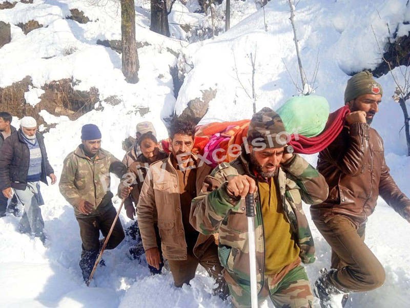 A pregnant woman being carried by policemen from snowclad Chilly village up to hospital in Doda. -Excelsior/Rafi Choudhary