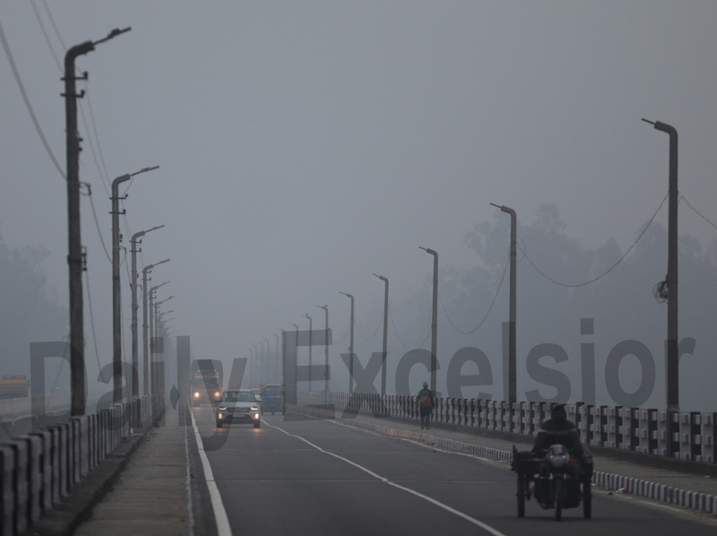 Vehicles move on Sidhra bridge during cold and foggy morning in Jammu on Thursday. —Excelsior/Rakesh