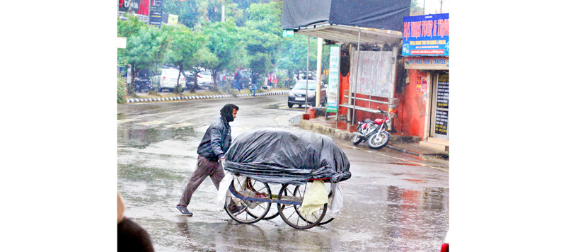 A man pushes his wheel cart during rains in Jammu. -Excelsior/Rakesh