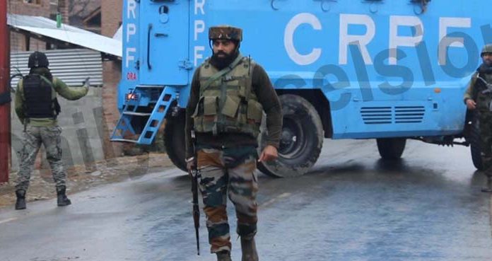 Troops stand guard at Okey village in Kulgam district during encounter on Tuesday. -Excelsior/Sajad Dar