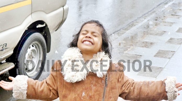 A child enjoys fresh snowfall in Srinagar on Tuesday. -Excelsior/Shakeel