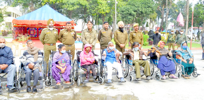 SSP Kathua, Romesh Chander Kotwal and other police officers posing for a photograph with specially abled persons at DPL Kathua after distributing wheel chairs among them on Wednesday.