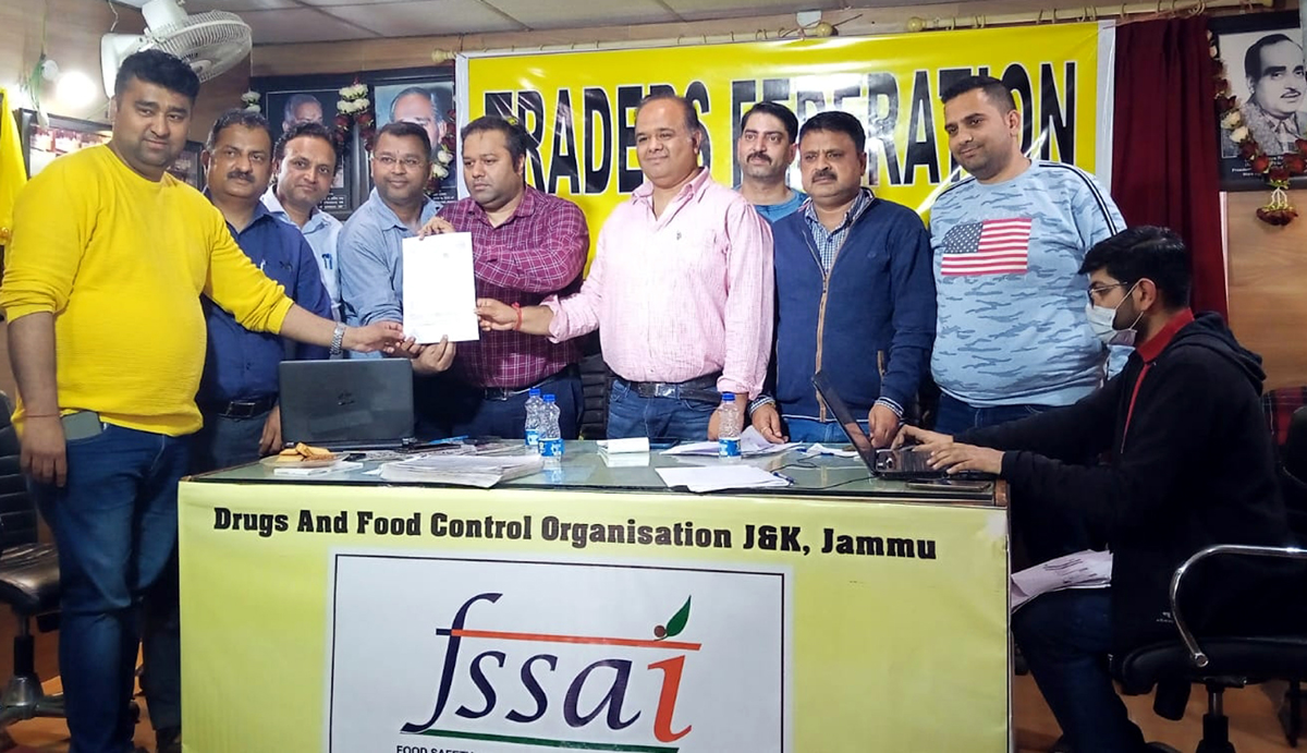 Officers of Food Safety Wing of Drugs and Food Control Organization issuing license to a Food Business Operator in presence of office bearers of Traders Federation Ware House Nehru Market Jammu.