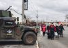 People walk past a military vehicle in Irpin, Ukraine. (UNI)