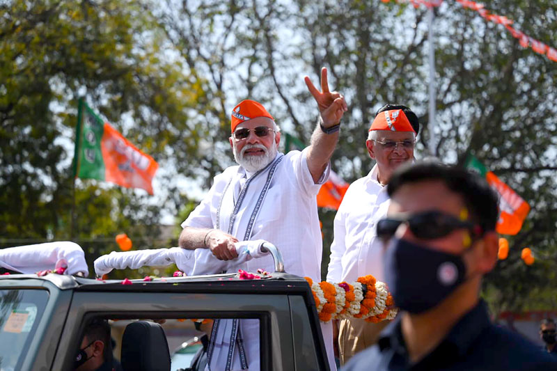 Prime Minister Narendra Modi flashing victory sign during the roadshow in Ahmedabad on Friday. (UNI)