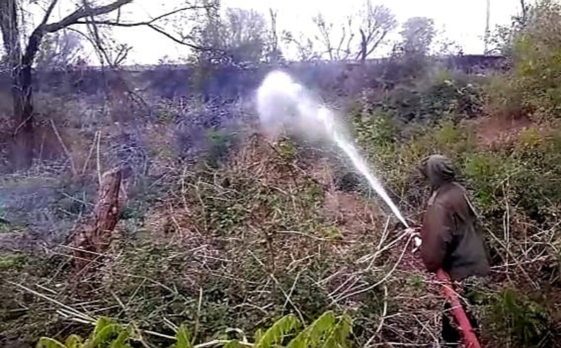 A fire fighter dousing flames in the bushes along railway track in Bari-Brahmana area of Samba district. — Excelsior/Nischant