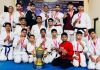 J&K Karate team posing for a group photograph alongwith trophy during the championship.