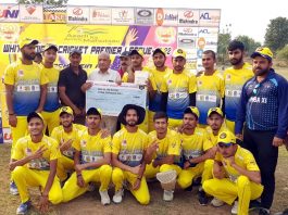 Former MLA Bharat Bhushan awarding a player while posing for a group photograph at Country Cricket Stadium Jammu on Tuesday.