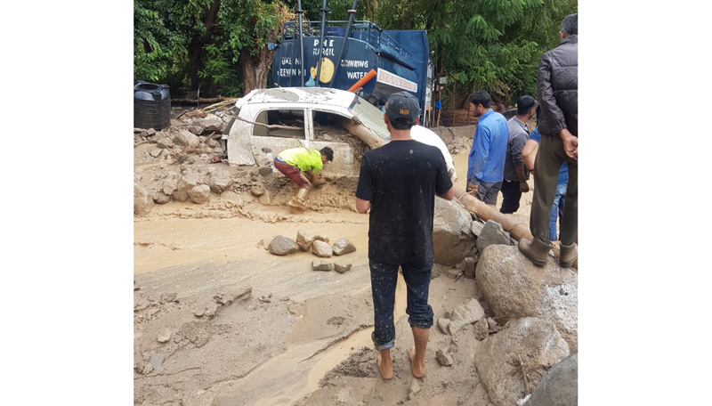 A car trapped in mud after flash flood in Kargil on Wednesday. -Excelsior/Basharat Ladakhi