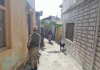 Security personnel stand guard during NIA raid in Doda on Monday.