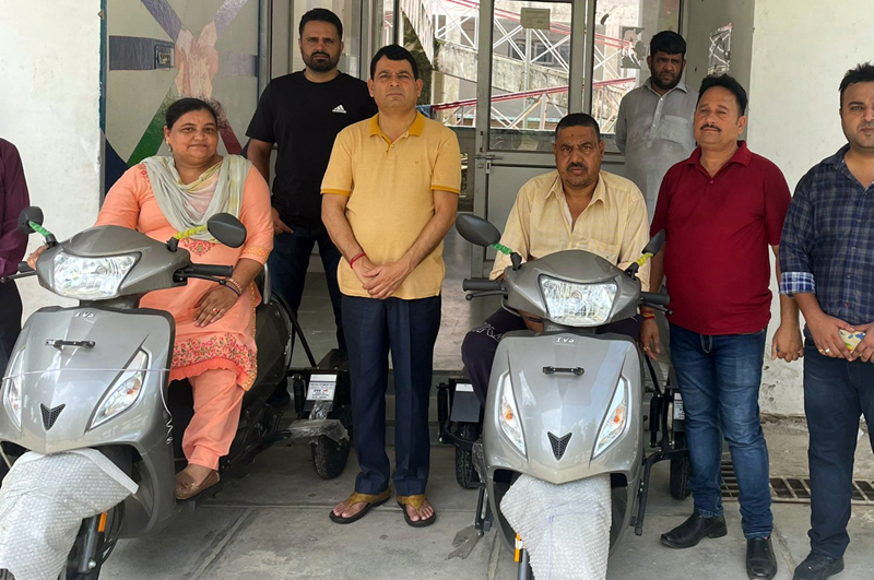 Physically challenged persons posing for a photograph with scooties given to them by DDC Suresh Sharma.