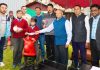 LG R K Mathur presenting sports equipment to students in a function at Leh on Wednesday.