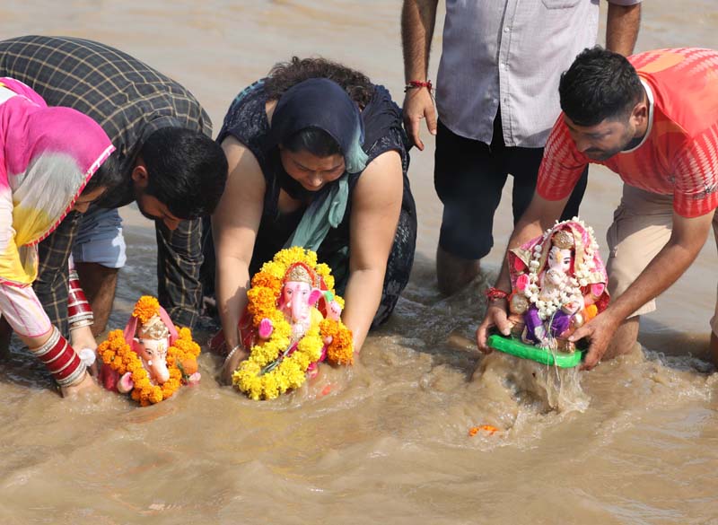 Devotees immersing idols of Lord Ganesha in river Tawi at Jammu on Friday. -Excelsior/Rakesh
