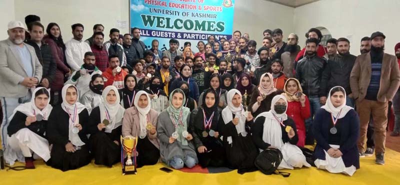 Winners displaying medals and trophies while posing for a group photograph at University of Kashmir in Srinagar.