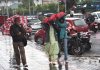 People walk during rain in Srinagar on Friday. — Excelsior/Shakeel