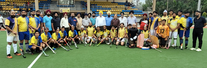Guests and match officials posing with winning hockey team at KK Hakku Stadium, Jammu.