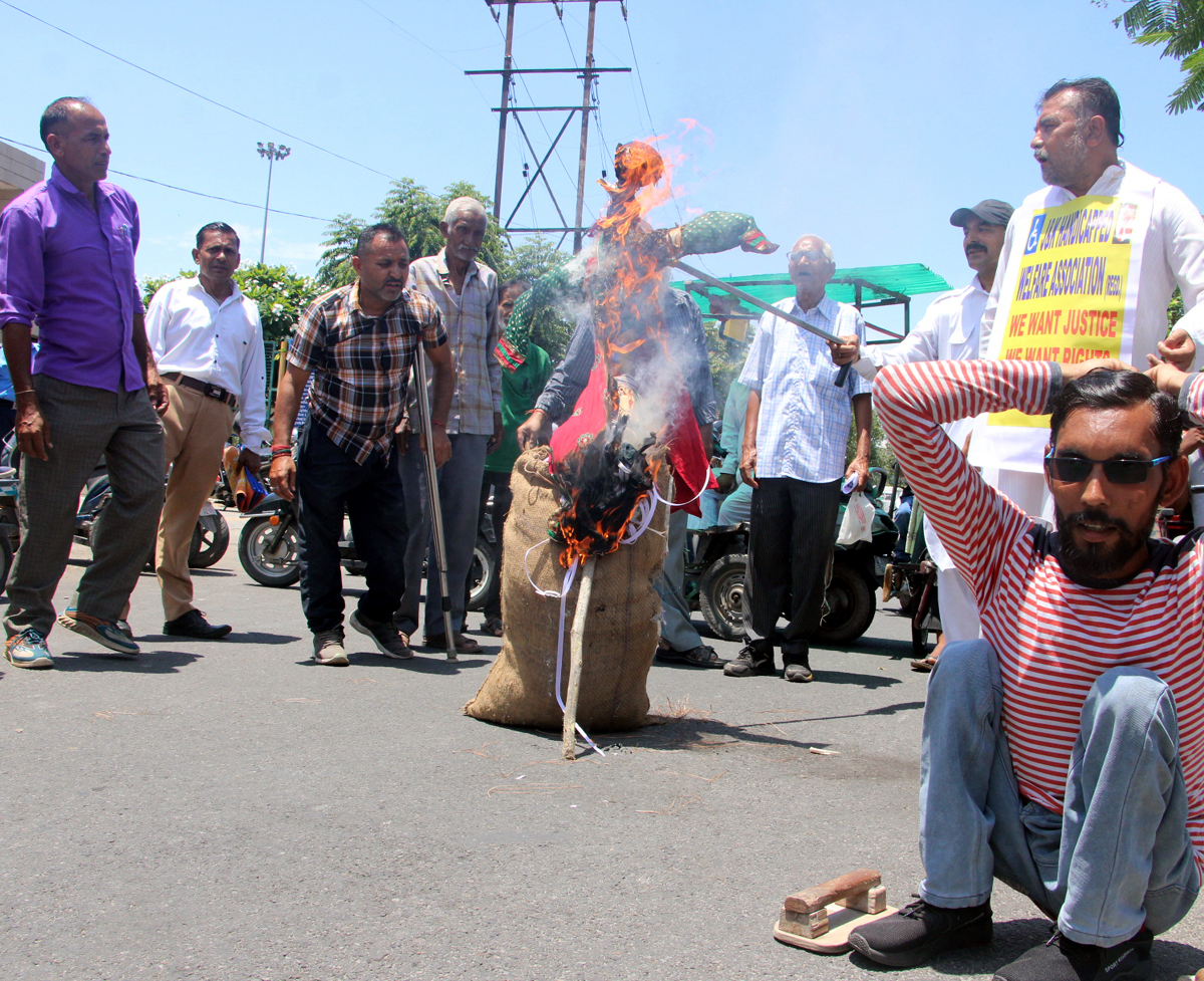 PWDs torching the effigy of Director Social Welfare during a protest in Jammu. -Excelsior/Rakesh