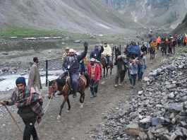 Pilgrims on their way to have darshan of Shiva Lingam near holy cave, in Baltal on Thursday. (UNI)