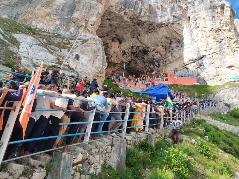 Yatris waiting in long queues at holy cave for darshan on Saturday.