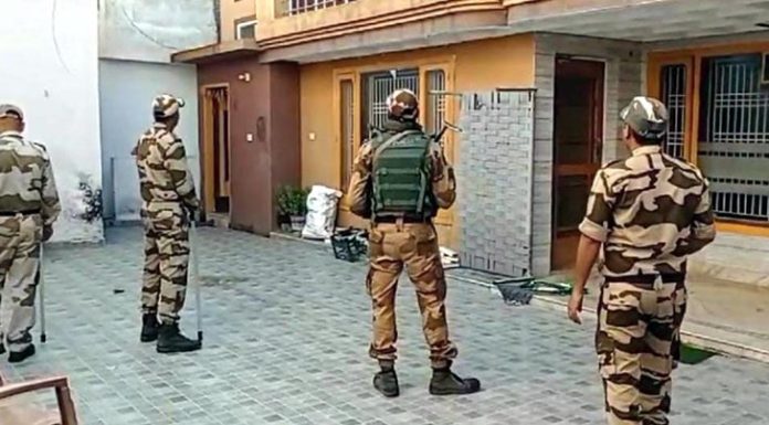 Security personnel guarding a house as a CBI team conducts raid in Bishnah town on Saturday.
