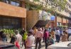 People gather outside their offices after tremors were felt due to an earthquake, in New Delhi