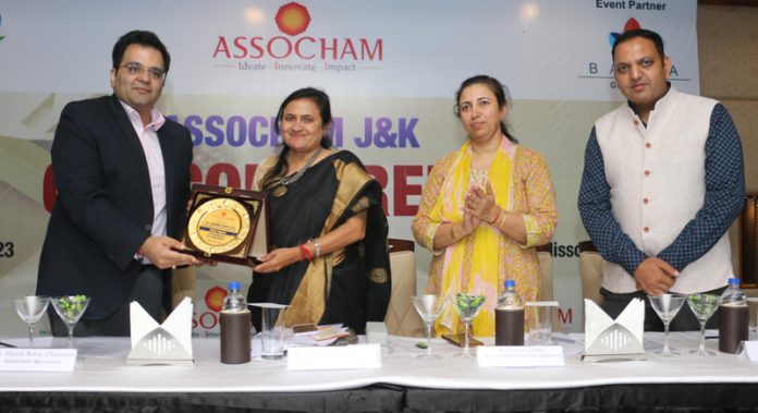 Manik Batra presenting memento to Dr Rashmi Singh, Commissioner State Taxes Department during J&K GST Conference.