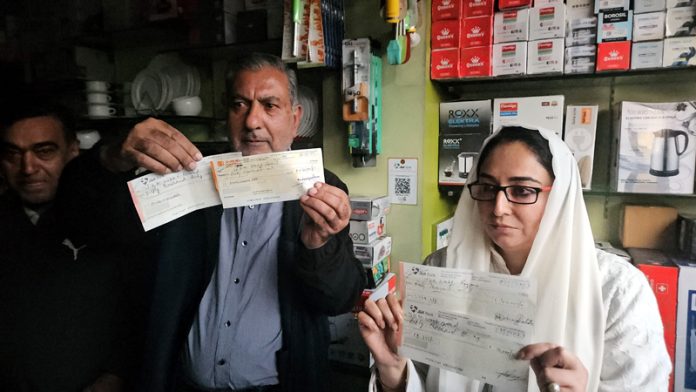 Waqf Chairperson, Dr Darakhshan Andrabi receiving rent cheques from traders at Lal Chowk in Srinagar on Thursday evening.
