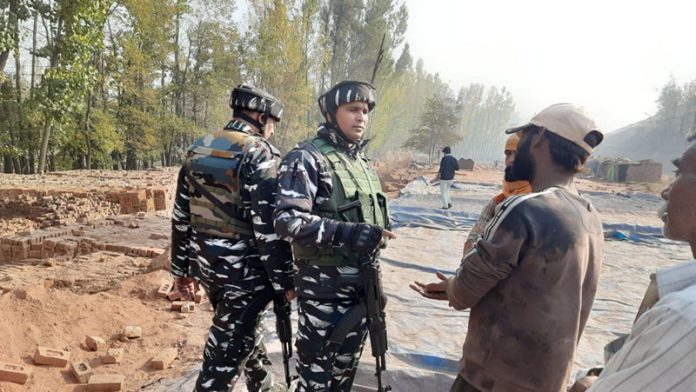 Security forces interacting with non-local labourers after a labourer was shot dead by the militants in South Kashmir's Pulwama district on Monday.(UNI)