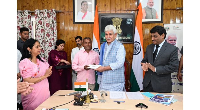 LG Manoj Sinha handing over land allotment letter to a beneficiary in Srinagar on Monday.