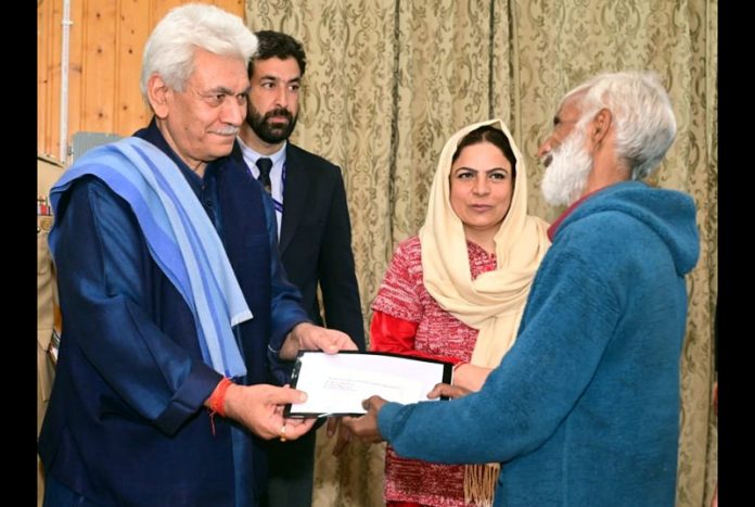 LG handing over land allotment letter to beneficiary at Baramulla