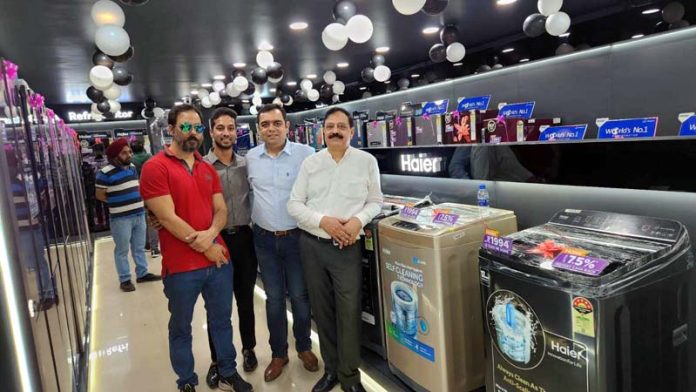 Proprietors of M/s Amit Electronics posing together in their showroom in Jammu.