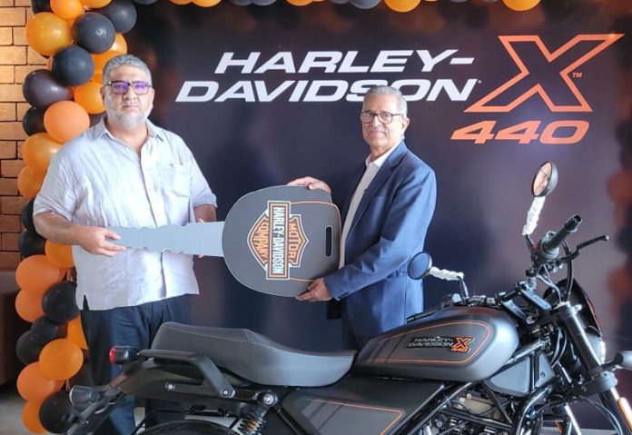 Representative of Harley Davidson handing over key of first Harley-Davidson X440 to official of Jamkash Biking.